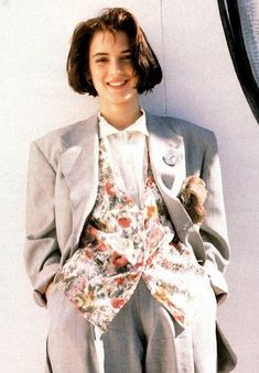 a woman wearing a suit and tie sitting on a chair