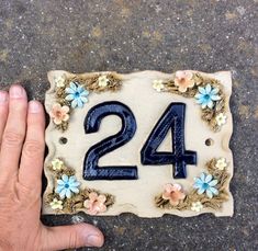 the number twenty four is decorated with flowers and blue icing on a stone slab