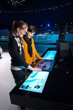 two girls looking at an interactive screen in a museum