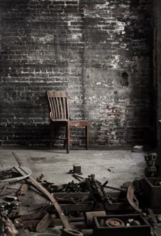 a wooden chair sitting on top of a floor next to a pile of broken furniture