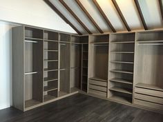 an empty room with some wooden shelves and shelving unit in the center, along with hard wood flooring