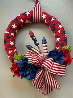 a patriotic wreath with red, white and blue flowers hanging on the wall next to a toothbrush