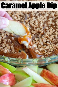 caramel apple dip in a glass bowl with apples and pecans