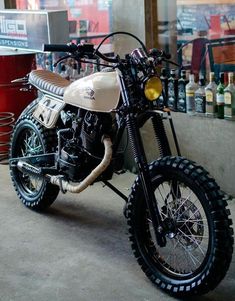 a dirt bike parked in front of a building with lots of bottles on the wall