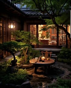 a table with candles on it sitting in the middle of a garden area at night