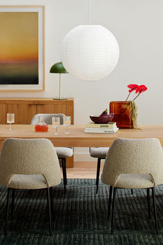 two chairs sitting at a table in front of a painting