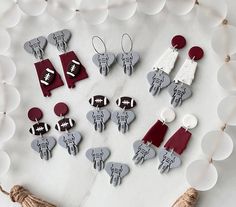 several pairs of earrings are arranged on a white surface with red and gray accents,