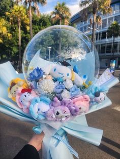 a hand holding a bubble filled with stuffed animals