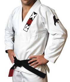 a man standing with his hands on his hips wearing a white karate suit and black belt