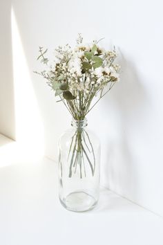 a glass vase filled with lots of white flowers