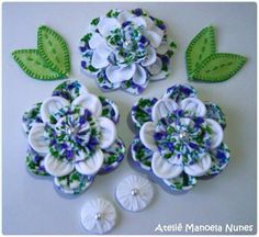 four flowers and leaves are shown on the white table top, with green leaves around them