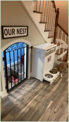 a dog laying on the floor in front of a refrigerator next to a stair case