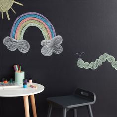 a child's room with chalk drawings on the wall and a rainbow painted on the wall