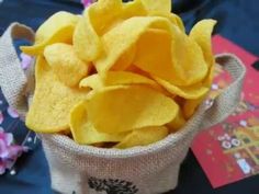 a bag filled with yellow potato chips sitting on top of a blue cloth covered table