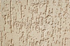 the texture of an old wall with writing on it and small holes in the plaster