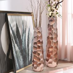 two vases with flowers in them sitting on a table next to a framed photograph