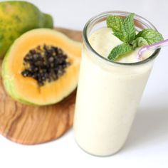 a smoothie and some fruit on a cutting board