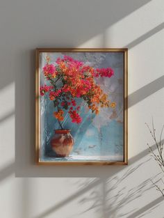 a painting hanging on the wall next to a vase with flowers in it and a plant