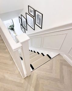 an overhead view of a hallway with pictures on the wall and stairs leading to another room