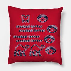 a red pillow with blue letters and an image of elephants, giraffes, and eyeballs on it