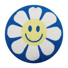 a blue and white flower with a smiley face on it's center, sitting in front of a white background