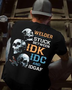 the back of a man wearing a black t - shirt with skulls on it and words that read welder stuck between idc and dgaf