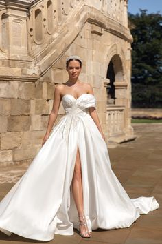 a woman in a white wedding dress posing for the camera