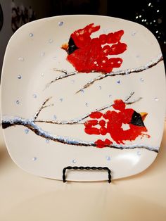 a white plate with red birds painted on it