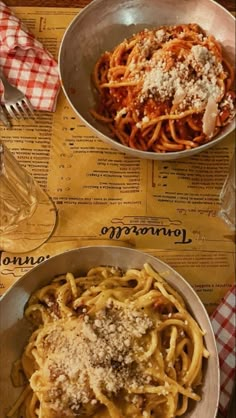 two bowls filled with pasta on top of a table