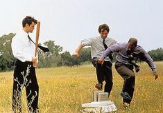 three young men are playing baseball in a field with tall grass and trees behind them