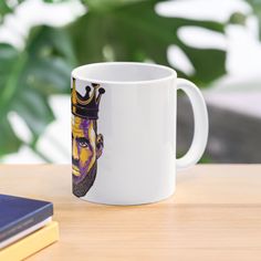 a white coffee mug with an image of a man's face on it sitting on a table