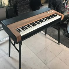 an electronic piano sitting on top of a tiled floor next to a drum and other musical equipment