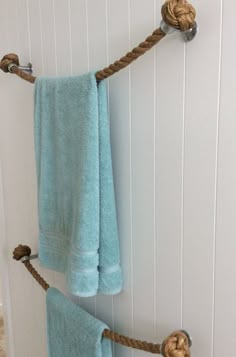 two blue towels hanging on a rope in a bathroom