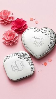 two personalized heart shaped compact mirrors on a pink background