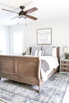 a bed room with a neatly made bed and a ceiling fan