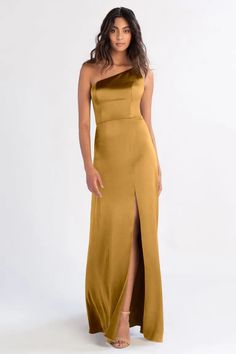 a woman wearing a gold dress with one side slited and the other side split open