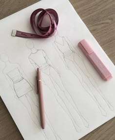 the drawing is being drawn on paper with a pink pen and ruler next to it