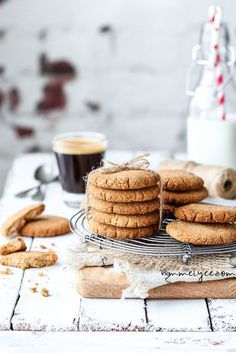 some cookies are stacked on top of each other near a cup of coffee and cinnamon sticks