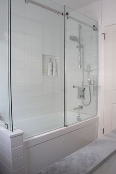 a white bathroom with a walk in shower next to a sink