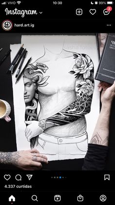 a person holding a book next to a drawing on top of a table with coffee and pencils