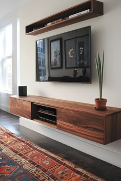 the entertainment center is made from wood and has two plants on it, along with an area rug