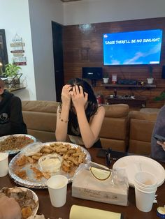 three people sitting at a table covered in food