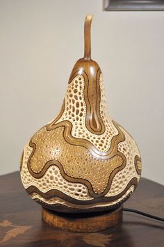 a brown and white vase sitting on top of a wooden table