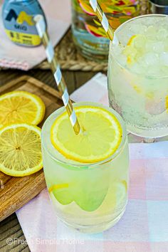 two glasses filled with lemonade sitting on top of a table