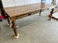 a wooden table sitting in the middle of a room next to other woodworking tools