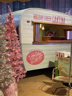 an old fashioned camper is decorated with pink christmas trees and holiday cheer canisters