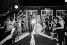 the bride and groom are walking down the aisle as guests throw confetti on them