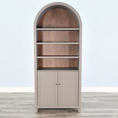 an arched bookcase with two doors and shelves