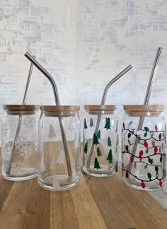 three glass jars with metal straws in them