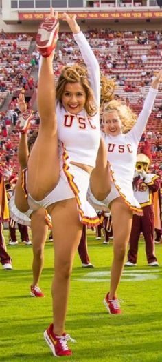 two cheerleaders are doing stunts on the field